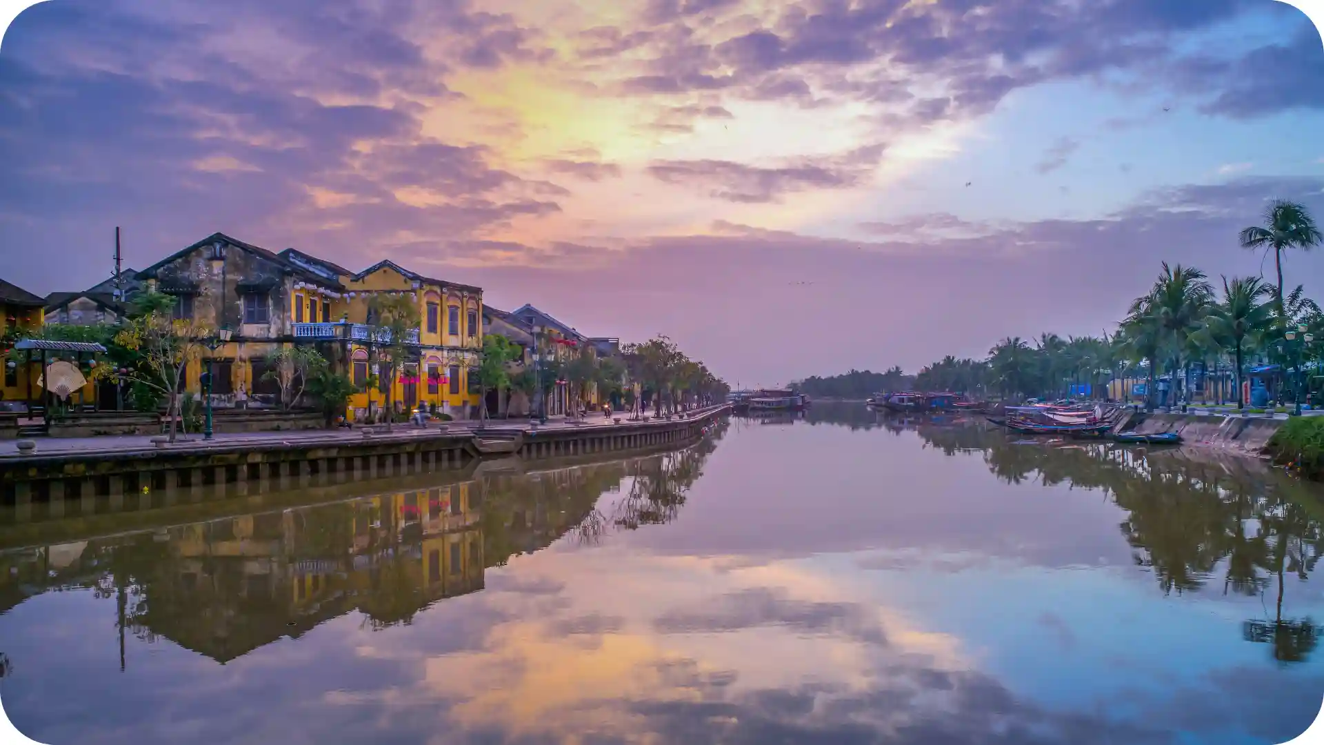 Hoi An ancient town Vietnam at sunset with colorful French colonial architecture, reflective river, and palm trees – Ghumora luxury Vietnam travel